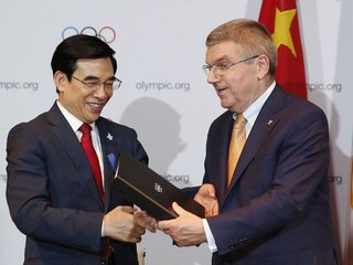Prezident Medzinárodného olympijského výboru Thomas Bach (vpravo) blahoželá starostovi Pekingu Wang An-šunovi k získaniu práva na organizáciu ZOH v roku 2022.