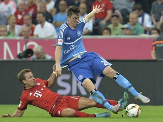 Mario Götze (vľavo) sa v súboji prvého kola nového ročníka I. bundesligy pokúša sklzom obrať o loptu hráča Hamburgu Michaela Gregoritscha.