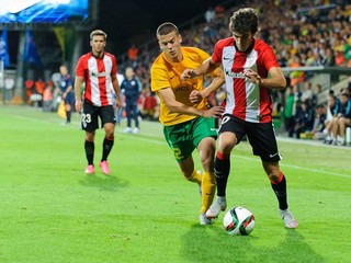 Hráč Žiliny László Bénes (v žltom) sa snaží odstaviť od lopty futbalistu Athletica Bilbao Iňiga Lekueho.