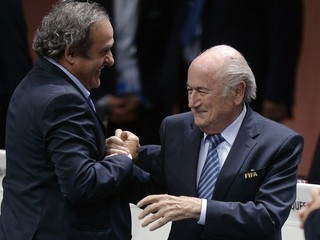 Staronový prezident FIFA Sepp Blatter (vpravo) prijíma gratulácie od viceprezidenta FIFA a prezidenta UEFA Michela Platiniho (vľavo).