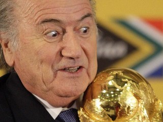 Sepp Blatter drží v rukách trofej pre majstrov sveta vo futbale.