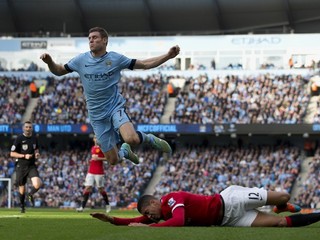 James Milner (hore) padá po zákroku obrancu Manchestru United Chrisa Smallinga.