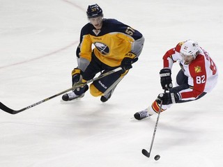 Tomáš Kopecký (vpravo) sa snaží udržať puk na hokejke pred hráčom Buffala Tylerom Myersom.
