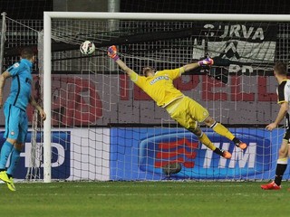 Brankár Udinese Orestis Karnezis sa márne naťahuje po lopte z kopačky Lukasa Podolského.