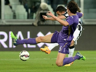Carlos Tévez strieľa spoza brániaceho hráča Fiorentiny a dáva jeden z troch gólov Juventusu.
