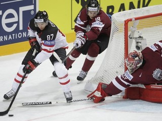 Kapitán kanadskej reprezentácie Sidney Crosby (vľavo) kontroluje puk v zápase s Lotyšskom.