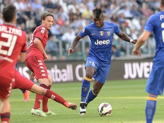 Futbalista Juventusu Paul Pogba (s loptou na kopačke) sa snaží presadiť cez brániacich hráčov Cagliari.