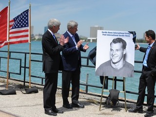 Portrét Gordieho Howea, pri ktorom aplaudajú Rick Snyder (vľavo) a Stephen Harper. Syn hokejovej legendy Murray Howe stojí vpravo.
