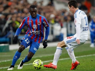 Obranca Caen Dennis Appiah (vľavo) v súbpji s Florianom Thauvinom z Marseille.