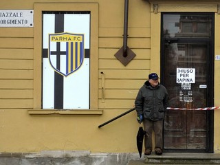 Na snímke z 8. marca stojí starší muž pred štadiónom v Parme. Nápis na dverách za jeho chrbtom hlási Chiuso per rapina (Zatvorené po lúpeži).