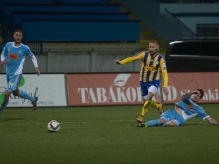 Slobodan Simovič (vpravo na zemi) vypichuje loptu Petrovi Štepanovskému z Dunajskej Stredy. Slovan zápas prehral 0:1.