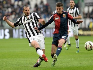Futbalista Juventusu Giorgio Chiellini centruje loptu cez brániaceho hráča Janova Zakaryu Bergdicha.
