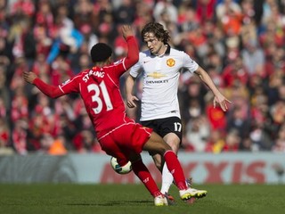 O loptu bojujú futbalista Manchestru United Daley Blind (v bielom) a hráč Liverpoolu Raheem Sterling.