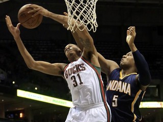 Pod košom bojujú o loptu vo vzduchu basketbalista Milwaukee John Henson (vľavo) a hráč Indiany Lavoy Allen.