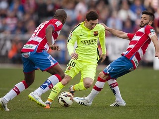 Lionel Messi (v strede) je najväčšou hviezdou FC Barcelona. Na snímke preniká cez dvoch hráčov Granady Dimitrija Foulquiera (vľavo) a Frana Rica (vpravo).