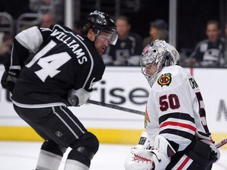 Brankár Chicaga Corey Crawford zastavuje pokus Justina Williamsa z LA.