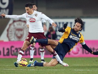 O loptu bojuje hráč Turína Migjen Xhevat Basha (vľavo) s futbalistom Verony Lucom Tonim.
