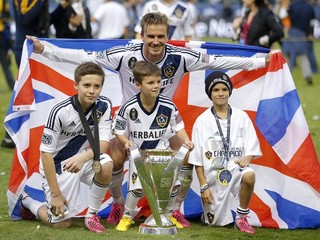 Na archívnej snímke z 1. decembra 2012 futbalista Los Angeles Galaxy David Beckham a jeho synovia Brooklyn (vľavo), Cruz (uprostred) a Romero (vpravo) pózujú s trofejou po víťazstve 3:1 v americkej MLS nad Houstonom Dynamo v Carsone.