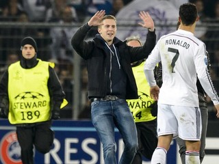 Futbalový fanúšik, ktorý vbehol na trávnik, beží ku Cristianovi Ronaldovi počas zápasu Ligy majstrov FC Bazilej - Real Madrid 26. novembra.