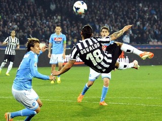 Osvaldo z Juventusu Turín strieľa vo vzduchu do lopty, v pozadí uprostred Slovák Marek Hamšík z Neapola v 31. kole talianskej Serie A 30. marca 2014 v Neapole.