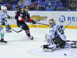 Útočník Slovana Tomáš Surový (uprostred) v zápase KHL pred brankárom Vladimirom Sochatským z Ufy.