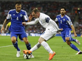 Wayne Rooney (vpredu) v súboji s Fabiom Vitaioliom zo San Marína (vľavo) vo futbalovom zápase 2. kola kvalifikácie EURO 2016 v Londýne 9. októbra.