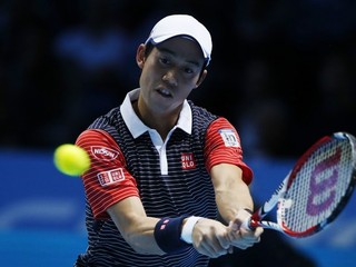 Japonský tenista Kei Nišikori odvracia loptičku Švajčiarovi Rogerovi Federerovi v zápase B-skupiny  Turnaja majstrov v Londýne 11. novembra 2014.