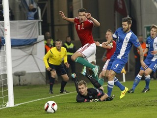 Fínsky brankár slovenského pôvodu Lukáš Hradecký (dole), hore maďarský hráč Adam Szalai, vpravo fínsky hráč Joona Toivio v zápase 4. kola kvalifikácie EURO 2016 v F-skupine Maďarsko - Fínsko v Budapešti 14. novembra 1:0.