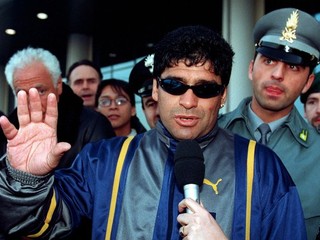 Bývalá argentínska futbalová hviezda Diego Armando Maradona zdraví po príchode na milánske letisko Malpensa 4. februára 1999.