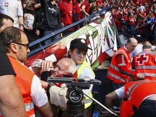 Záchranári pomáhajú fanúšikovi Osasuny po páde bariéry na štadióne.