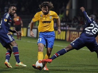 Pirlo (v strede) v súboji s dvomi hráčmi Lyonu.