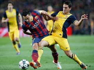 Koke v žltom drese Atlética a Xavi v drese Barcelony.