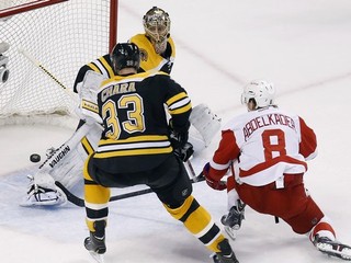 Brankár Bostonu Tuukka Rask zastavuje strelu hráča Detroitu Justina Abdelkadera, vľavo je Zdeno Chára.