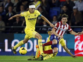 V žltom drese Soriano, futbalista FC Villarreal v súboji s Davidom Villom s Atlética Madrid.
