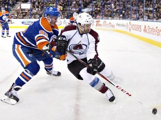 Slovenský obranca Martin Marinčin (vľavo) zažil v NHL víťazný debut, keď jeho Edmonton v noci na piatok 6. decembra 2013 rozdrvil Colorado 8:2. S Marcinčinom bojuje hráč Colorada Maxime Talbot.