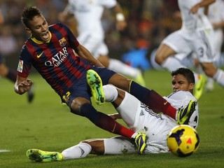 Neymar v súboji o loptu s Raphaelom Varanom z Realu (vpravo).