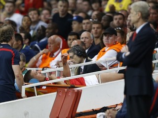 Zranený útočník Arsenalu Lukas Podolski opúšťa ihrisko na nosidlách v odvete play off futbalovej Ligy majstrov Arsenal Londýn - Fenerbahce Istanbul (2:0).