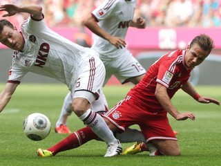 Futbalista Norimbergu Niklas Stark (vľavo) a hráč Bayernu Mníchov Mario Götze bojujú o loptu v zápase bundesligy.