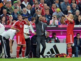 Pep Guardiola gestikuluje smerom k hráčom v jeho prvom zápase v bundeslige.