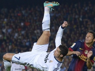 Futbalista FC Barcelona Adriano Correia z Brazílie (vpravo) a hráč Realu Madrid Cristiano Ronaldo v súboji o loptu v prestížnom El Clasicu 7. októbra 2012 v Barcelone.