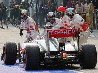 Technici odtláčajú Buttona s uvoľneným predným pravým kolesom späť do boxov.