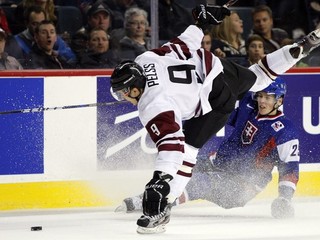 Slovák Martin Gernát (vpravo) a Lotyš Kristians Pelss v súboji v základnej skupine na svetovom šampionáte do 20 rokov v Calgary v decembri 2011.