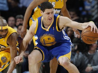 Rozohrávač Golden State Warriors Klay Thompson, pred dobiedzajúcim Coreym Brewerom z tímu Denver Nuggets. Golden State prekvapujúco s tromi rozohrávačmi vyhral v Denveri vysoko 131:117.