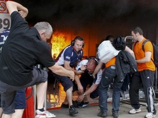 Zraneného člena tímu Williams vynášajú z priestorov, kde vypukol požiar.