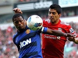 Patrice Evra (v modrom) v súboji s Luisom Suárezom.