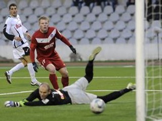 Trnavčan Radoslav Ciprys (vľavo) strieľa gól cez brániaceho Trenčana Petra Čögleya (uprostred) a brankára Miloša Volešáka.