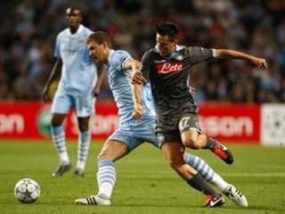Kapitán Neapola Marek Hamšík bojuje o loptu s hráčom Manchester City Edinom Dzekom.