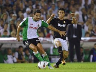 Portugalský útočník Realu Madrid Cristiano Ronaldo (vpravo) v súboji o loptu s Grékom v drese Racingu Santander Alexandrosom Tziolisom.