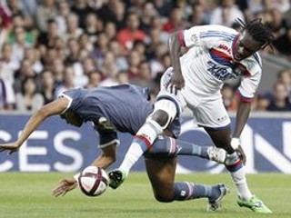 Futbalista Lyonu Bafe Gomis (vpravo) a hráč Bordeaux Carlos Henrique Dos Santos Souza bojujú o loptu počas zápasu francúzskej Ligue 1 v Lyone.