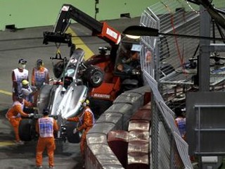 Monopost Michaela Schumachera odvážajú po nehode na Singapurskej Veľkej cene.